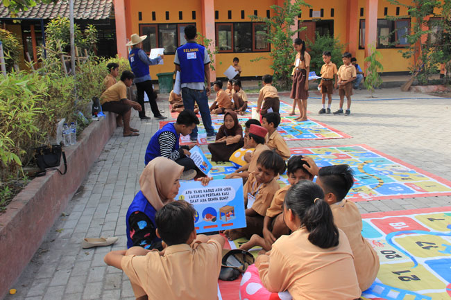 Several vinyl mats were laid out on the cobblestone street, and participants sat on them in groups and listened to the talk while looking at flip charts, etc.