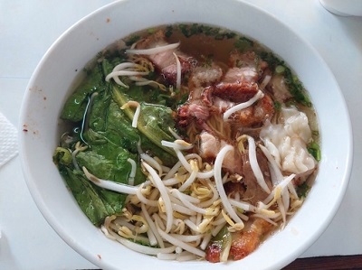 A top view of a noodle dish served in a white bowl