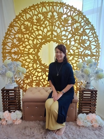 Masako Umeeda sitting in a chair with her back to the relief